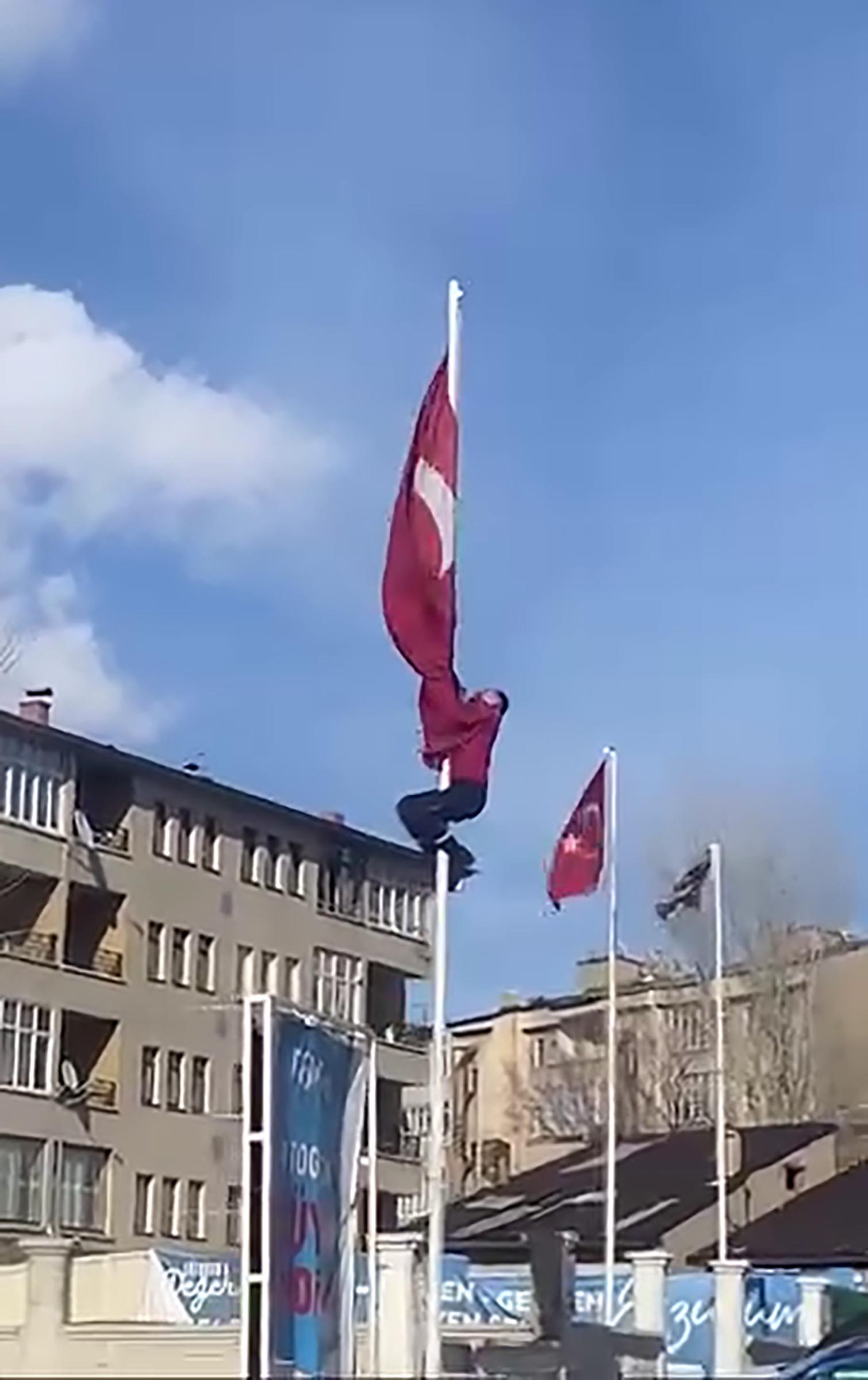 Rüzgârda dolanan bayrağı düzeltmek için 15 metrelik direğe tırmandı; o anlar görüntülendi